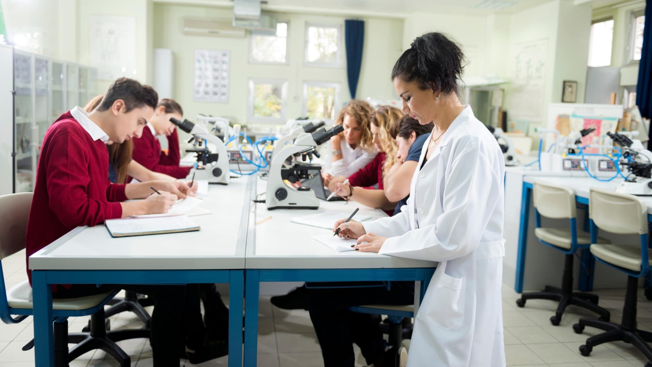 biology teaching assistant and students in laboratory